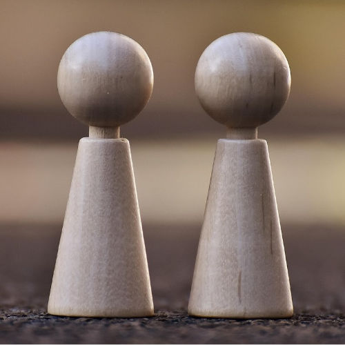 Zwei hölzerne Spielfiguren stehen nebeneinander und symbolisieren die systemische Aufstellung in der Praxis Christina Pielken.