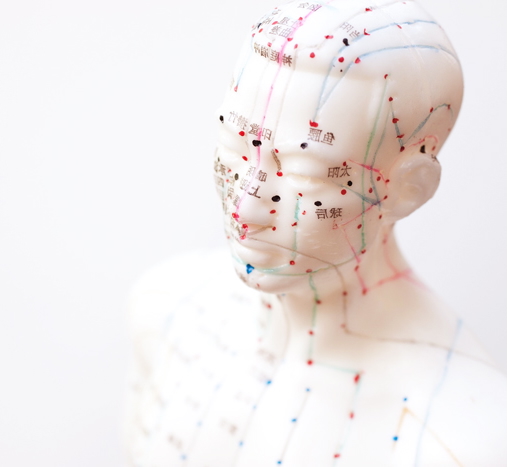 Akupunkturpunkte aus der TCM auf einer hellen Figur eingezeichnet