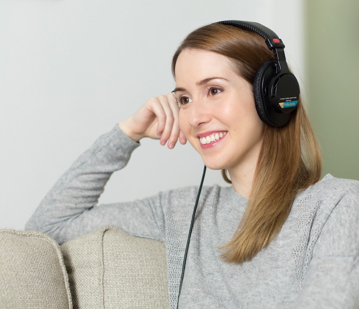 Frau mit Kopfhörern hat Online-Video-Termin mit Psychotherapie-Praxis