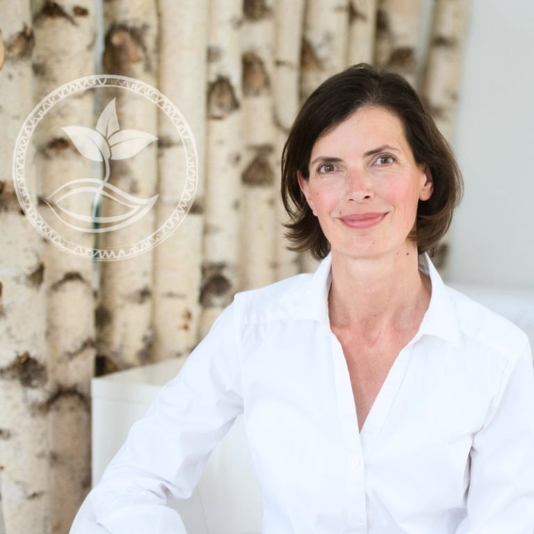 Therapeutin Christina Pielken sitzt vor Birkenstämmen in der Praxis, Vorbereitung auf einen Online-Termin