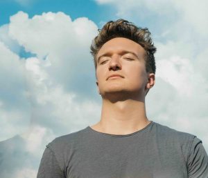 Mann mit geschlossenen Augen übt Entspannungsverfahren Autogenes Training, eine Methode der Psychotherapie-Praxis Pielken